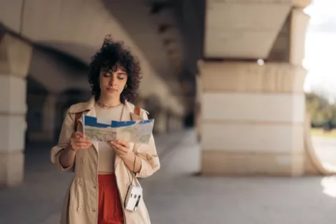 Une jeune femme consulte une carte en voyage dans la rue