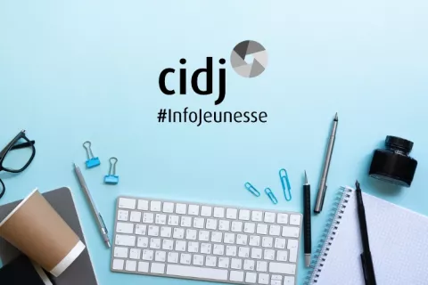 Un clavier d'ordinateur et des accesoires de bureau sont disposés sur une table