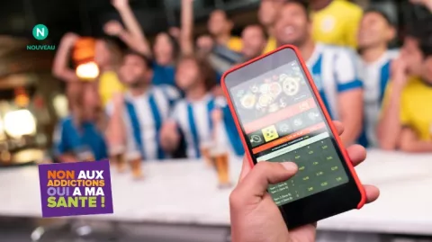 Des jeunes parient sur leur téléphone et regardent des matchs