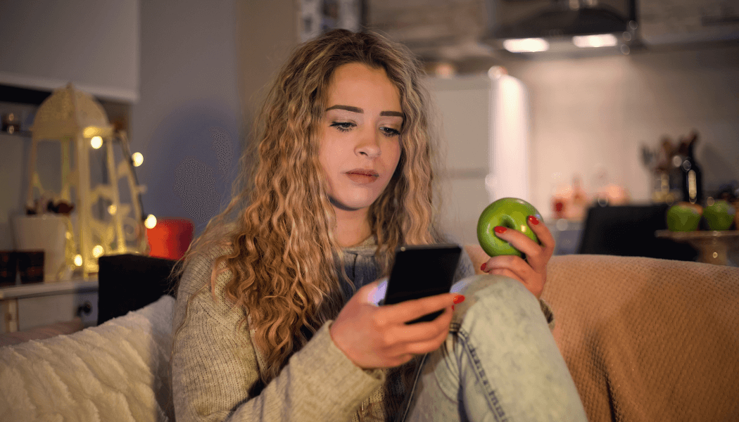 Une jeune femme regarde son téléphone