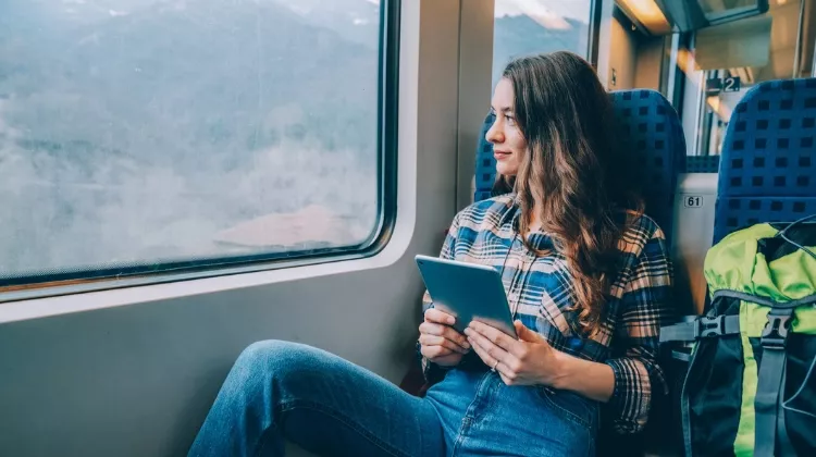 Une jeune femme dans le train regarde par la fenêtre