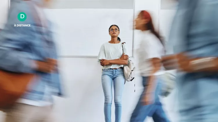 Une jeune femme seule est contre le mur, des passants continuent leur chemin