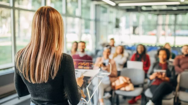 Une jeune femme présente un projet devant un groupe